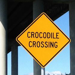 Close-up of road sign against sky