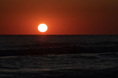 Scenic view of sea against orange sky