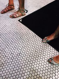 Low section of woman standing on tiled floor