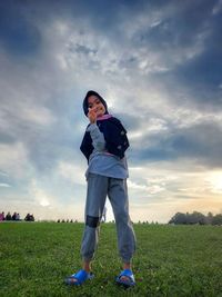 A girl standing on field against sky