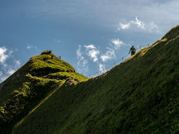 Low angle view of green mountains against sky