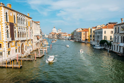 Boats in canal amidst buildings in city