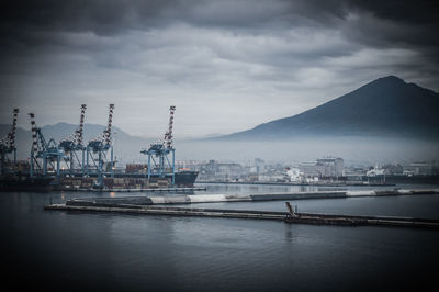 Commercial dock by sea against sky