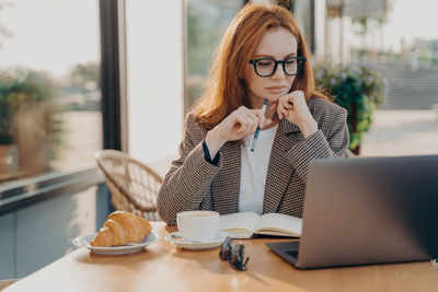 Businesswoman looking at laptop while sitting at cafe