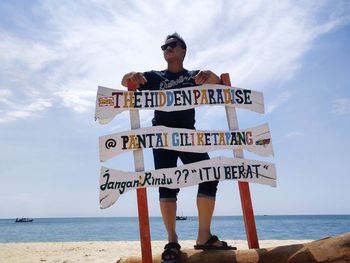 Man standing on beach by sea against sky