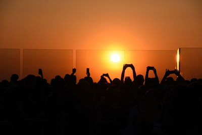 Silhouette people on top of rockefeller center during sunset