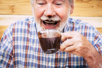 Happy senior man drinking coffee at home