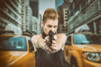 Portrait of young woman photographing in city