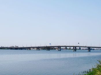 Bridge over sea against clear sky