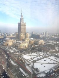 High angle view of city buildings against cloudy sky