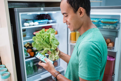 Side view of man holding ice cream in store