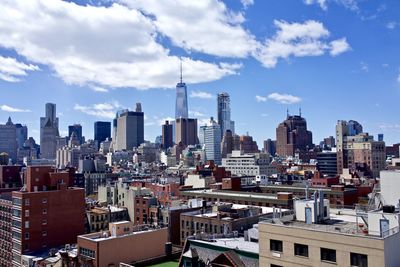 Modern buildings in city against cloudy sky