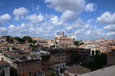 Scenic view of residential district against cloudy sky