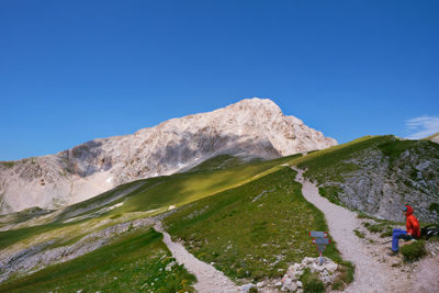 Hiker in the path and in the background the gran sasso d'italia abruzzo
