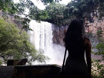 Rear view of woman looking at waterfall