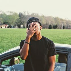 Young man standing by car