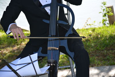 Midsection of man playing musical instrument