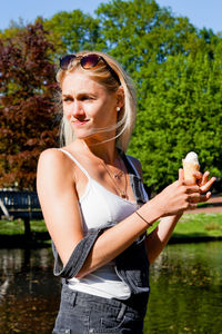 Young woman wearing hat standing by lake