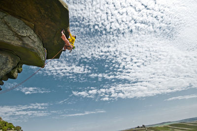Woman climbing at windgather rocks in the british peak district