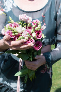 Middle-aged woman with a bouquet of pink eustomas a gift for mother's day,spring