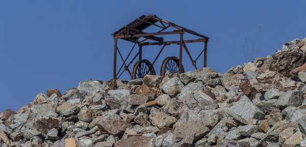 Low angle view of old construction site against clear blue sky