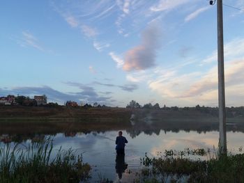 Rear view of man on lake against sky