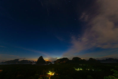 Scenic view of illuminated mountains against sky at night