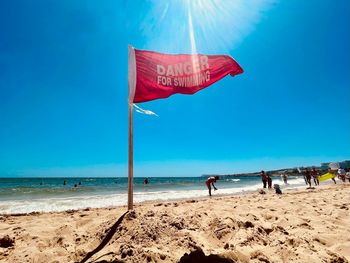 People on beach against blue sky