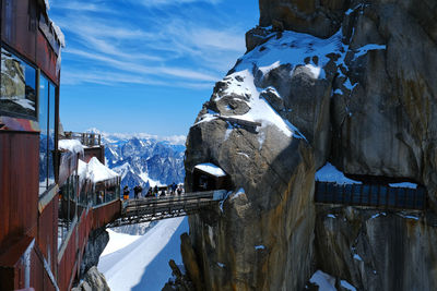 Panoramic view of people on snowcapped mountains against sky