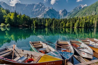 Boats moored in lake against mountains