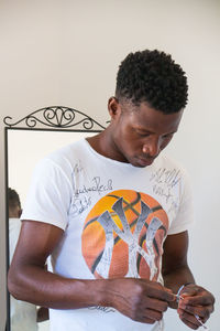 Young man standing against wall