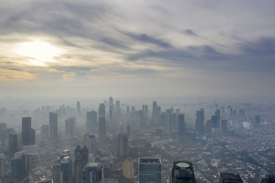 Aerial view of buildings in city against sky during sunset