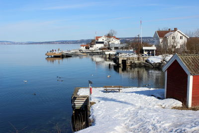 Scenic view of houses by building against sky during winter