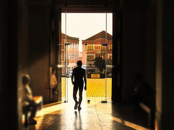 Rear view of silhouette man walking in building