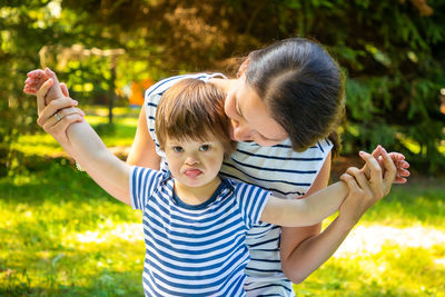 Portrait of mother and son playing in public park