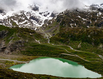 Scenic view of a mountain lake between snowcapped mountains against sky