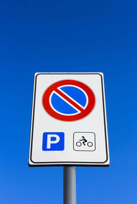 Low angle view of no parking sign clear blue sky