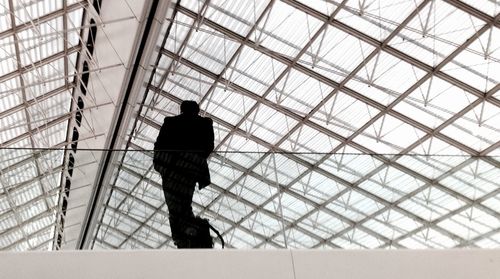 Low angle view of silhouette man standing on ceiling