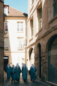 Rear view of women walking in alley