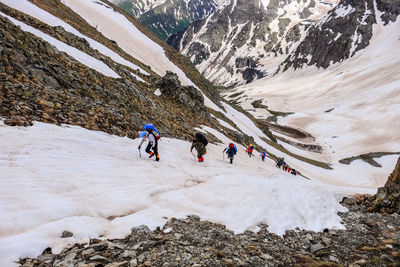 People skiing on snowcapped mountain during winter