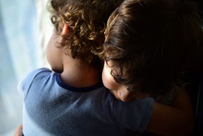 Siblings embracing at home