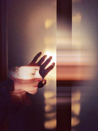 Surreal portrait of woman and her hand by window at home