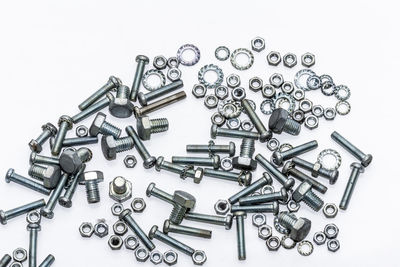 Close-up of screws and nuts over white background