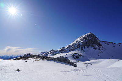 Scenic view of snowcapped mountains against clear blue sky