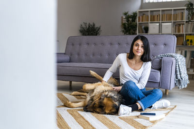 Young woman sitting on a cat looking away