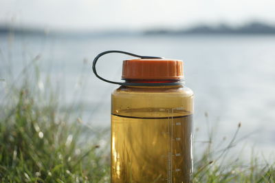 Close-up of bottle against calm sea