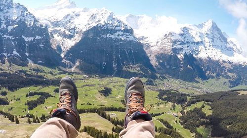 Low section of man on mountain against sky