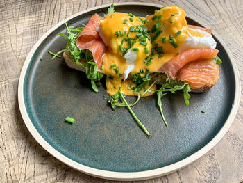 Healthy breakfast or brunch in a cafe. eggs benedict poached eggs with smoked salmon rocket on toast