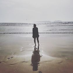 Full length rear view of man standing on beach