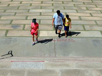 High angle view of people walking on street leading towards steps
